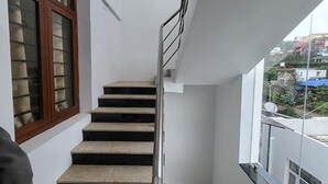 A staircase with a metal handrail leading to a balcony. - Fabhotel Sri Vari Studio Apartment (Kodaikanal)
