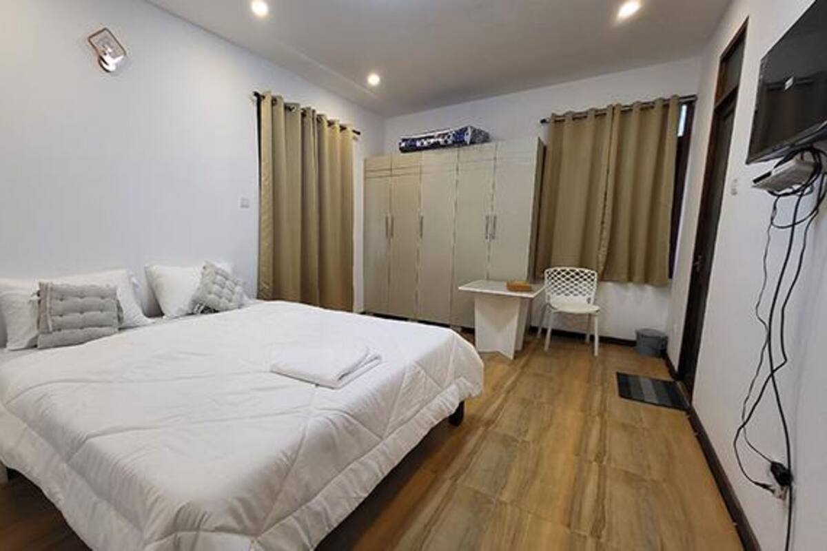 Een slaapkamer met een bed, een bureau en een stoel.