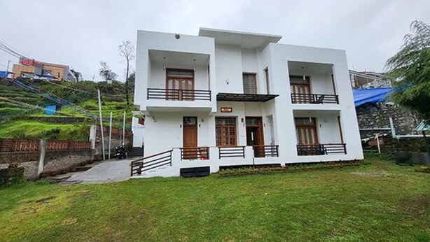 A two-story building with a flat roof, multiple balconies, and a small front porch. - Fabhotel Sri Vari Studio Apartment (Kodaikanal)