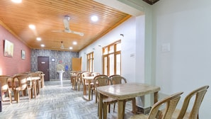 A dining area with wooden ceiling, tiled floor, and multiple dining tables and chairs. - Fabhotel The Legend Residency (Srinagar)