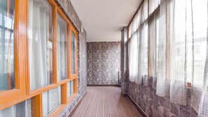 A corridor with patterned stone walls, wooden-framed windows, and a striped carpet. - Fabhotel The Legend Residency (Srinagar)