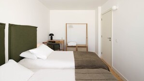 A hotel room with a bed, a desk, and a wardrobe. - Azul Downtown Apartments - Sé Velha (Coimbra)
