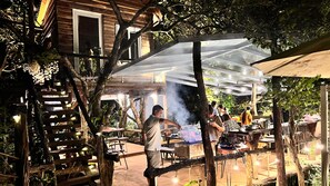 An outdoor dining area with wooden furniture and a transparent roof structure.