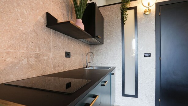 A modern kitchen with a dark countertop, built-in cabinets, and a black door. - Torino Centro, Il Principino (Torino)