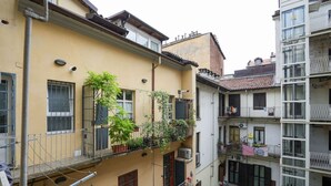 A multi-story residential building with balconies, some with plants. - Torino Centro, Gioberti Suite (Torino)