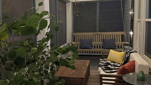A cozy indoor seating area with a wooden bench, a sofa with striped cushions, and a small table.