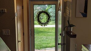 Un corridoio con pavimento in legno, una porta decorata con una ghirlanda e un cartello sopra la porta che recita 'FAMILY loves on first blessings'.