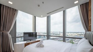 A modern hotel room with a large bed, a flat-screen TV, and a city view. - Landmark 81 Luxury - SaigonHomes (Ho Chi Minh City)