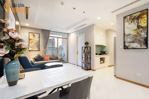 Apartamento básico, 3 quartos, sacada, vista para a cidade | Área de estar | TV de tela plana 40 polegadas com canais via satélite, smart speakers