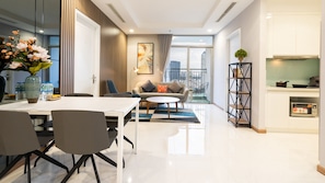 Relax in a stylish living area with a dining table, sofa, and city views from the large window.