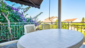 A round table with a white surface and a chair with a striped backrest on a balcony. - Maldini by Interhome (Zadar/Sukošan)