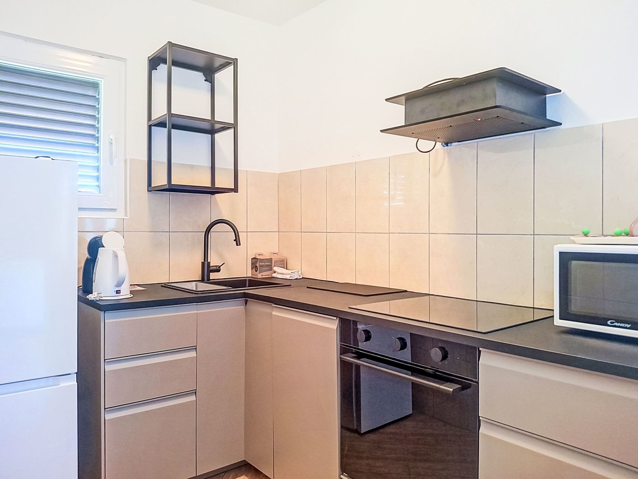 Una cocina compacta con un lavamanos, estufa y microondas.
