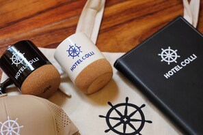 Un livre à la couverture en cuir noir, orné d’un logo représentant un gouvernail de bateau et portant l’inscription « HÔTEL COLLI ».