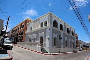 A building with a white facade, multiple arches, and a sign reading "NAQ".