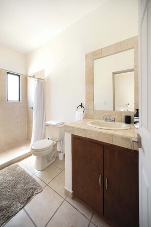 A bathroom with a toilet, sink, and shower. - Casa Alonso | Spacious House with Private Courtyard in San Jose (San José del Cabo)