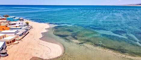 Una playa cerca, sillas reclinables de playa, toallas de playa