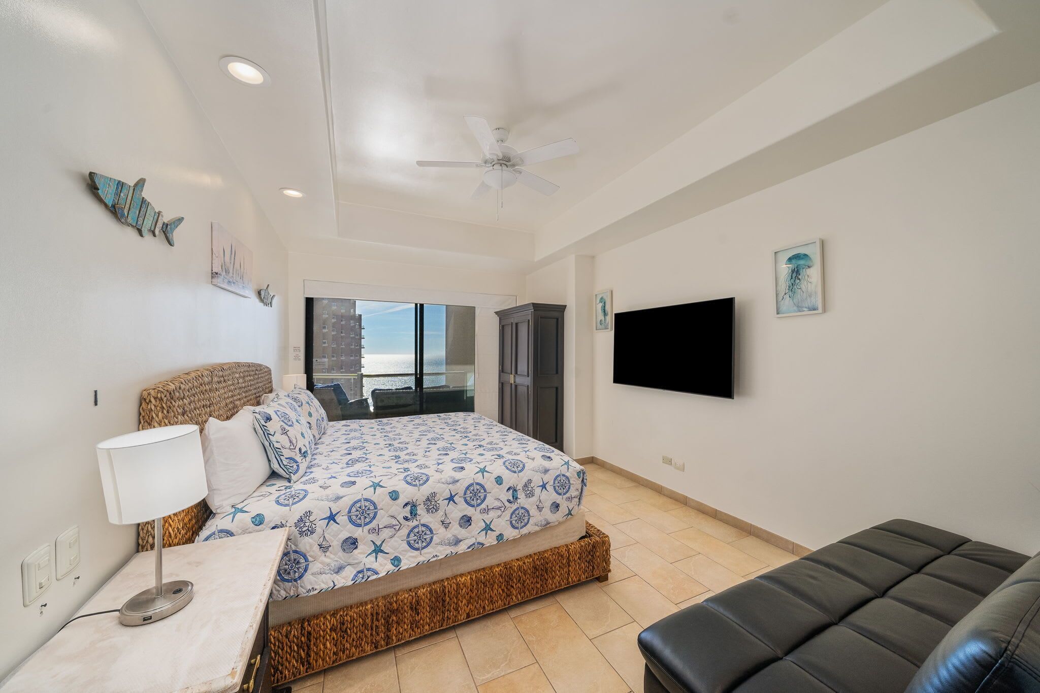 Spacious primary suite with king bed, flat-screen TV, and access to a private oceanfront balcony.