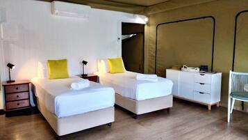 Una habitación con dos camas, un escritorio, una silla y un armario.