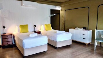 Una habitación con dos camas, un escritorio, una silla y un armario.