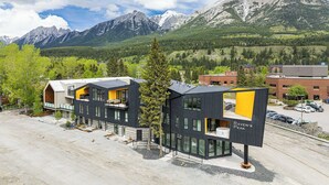 Un edificio moderno con techo plano, ventanas amplias y un cartel que dice 'Raven's Peak'.