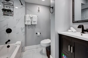 Un bagno moderno con vasca, servizi igienici e lavandino.
