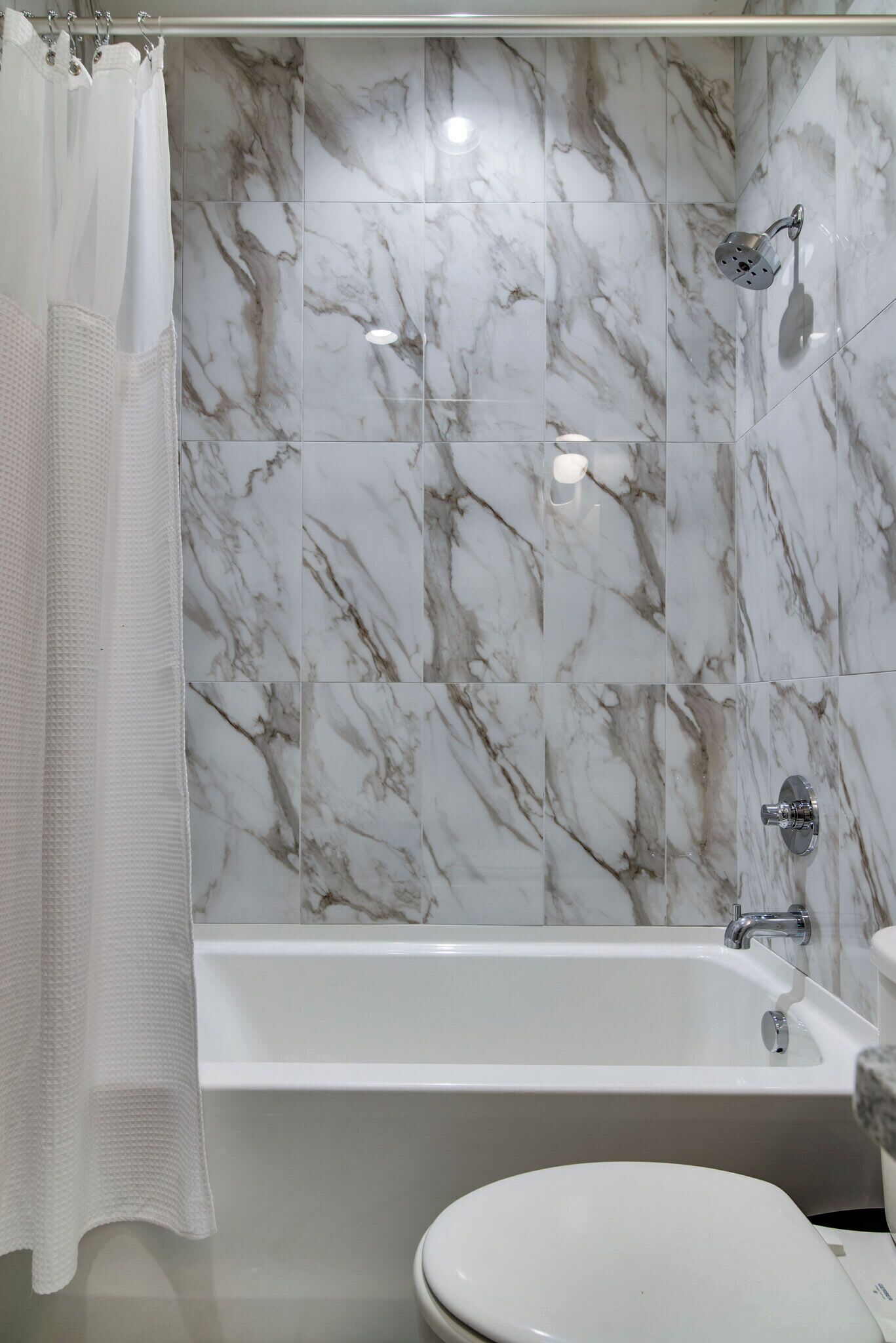 Un baño con bañera, ducha y retrete.
