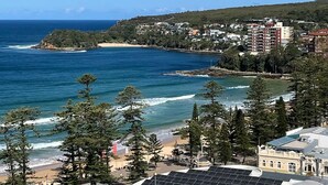 A coastal town with a beach, ocean, and residential buildings. - Beachfront Living, Manly Beach, Sydney (Manly)