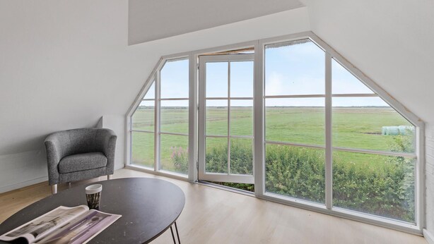A room with a large window offering a view of a green field and a clear sky. - Nice home in Janderup Vestj with sauna (Janderup Vestj)