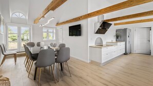 A spacious kitchen with wooden beams, a built-in TV, and a modern fridge. - Nice home in Janderup Vestj with sauna (Janderup Vestj)