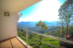 A balcony with a metal railing overlooking a lush green valley and distant mountains. - Samrakshitha - The Villa (Kotagiri)