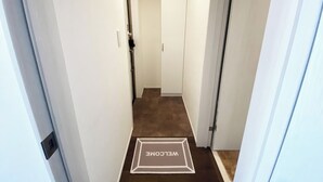 A hallway with a welcome mat at the end. - Skytree & Asakusa in front! Newly built clean apt! (墨田区)
