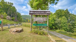 A wooden sign with "ELBOW LANDING" and "MARRIAGE OFFICIAN" written on it, surrounded by greenery and a road. - Cozy Luray Cabin w/ Views: Near Hiking Trails! (Luray)