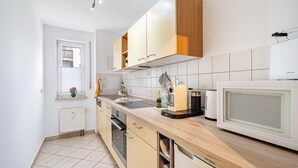 Une cuisine moderne avec des meubles en bois, un four à micro-ondes et un four encastré.
