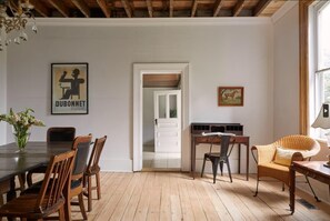 A dining area with a wooden table and chairs, a doorway leading to another room, and a framed picture on the wall. - 5 Bdrm w/ private beach amazing lake views (Prince Edward)