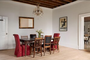 A dining room with a wooden table and chairs, a chandelier, a framed picture, and a door. - 5 Bdrm w/ private beach amazing lake views (Prince Edward)