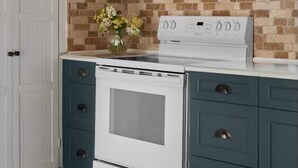 A kitchen with white cabinets, a white stove, and a tiled backsplash. - 5 Bdrm w/ private beach amazing lake views (Prince Edward)