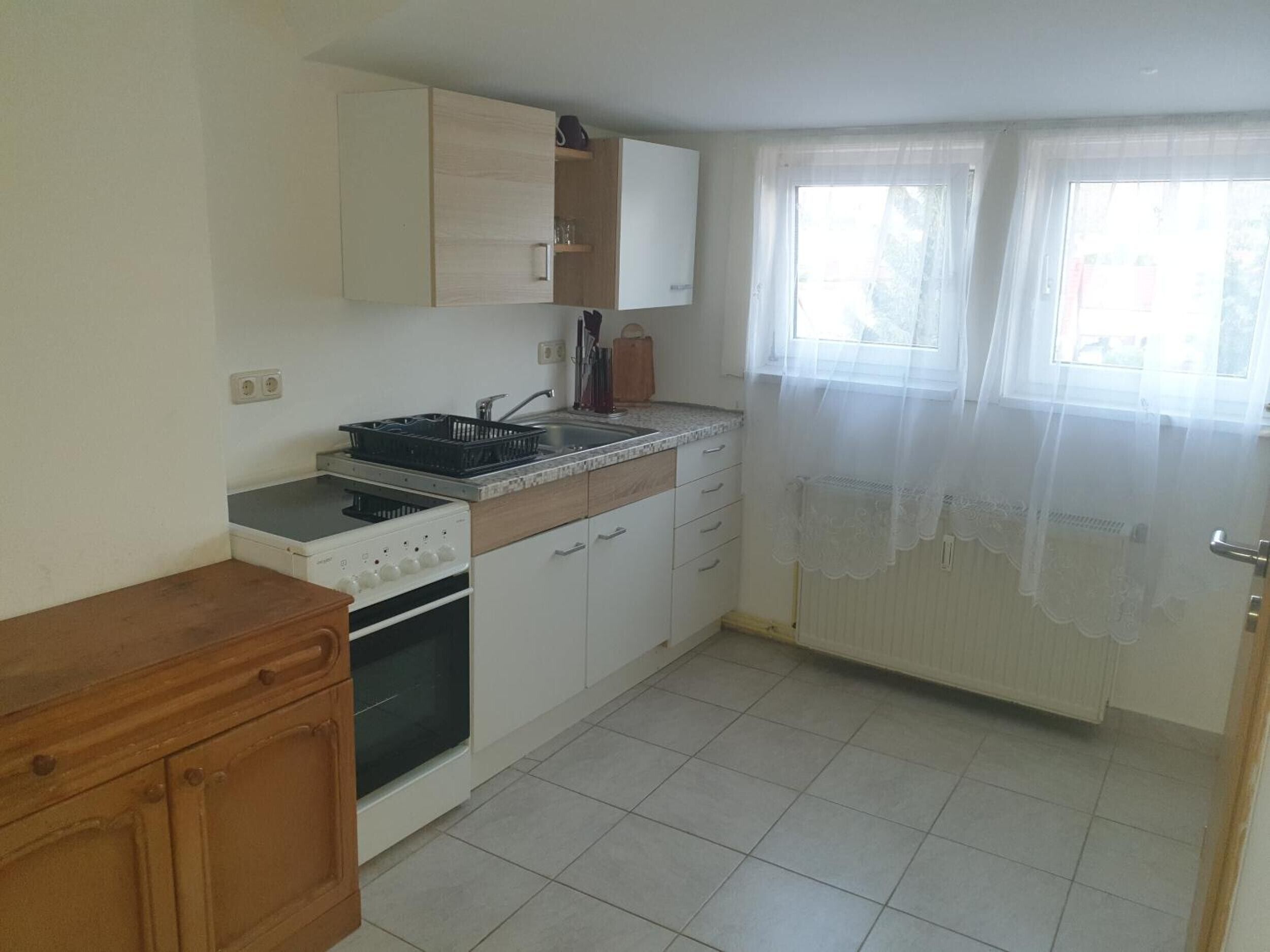 A kitchen with a stove, oven, sink, and cabinets.