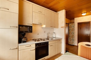 A kitchen with light wooden cabinets, a microwave, a coffee maker, a stove, and a sink. - "Haus zur Laterne" with Mountain View, Shared Garden and Wi-Fi (Willingen (Upland))
