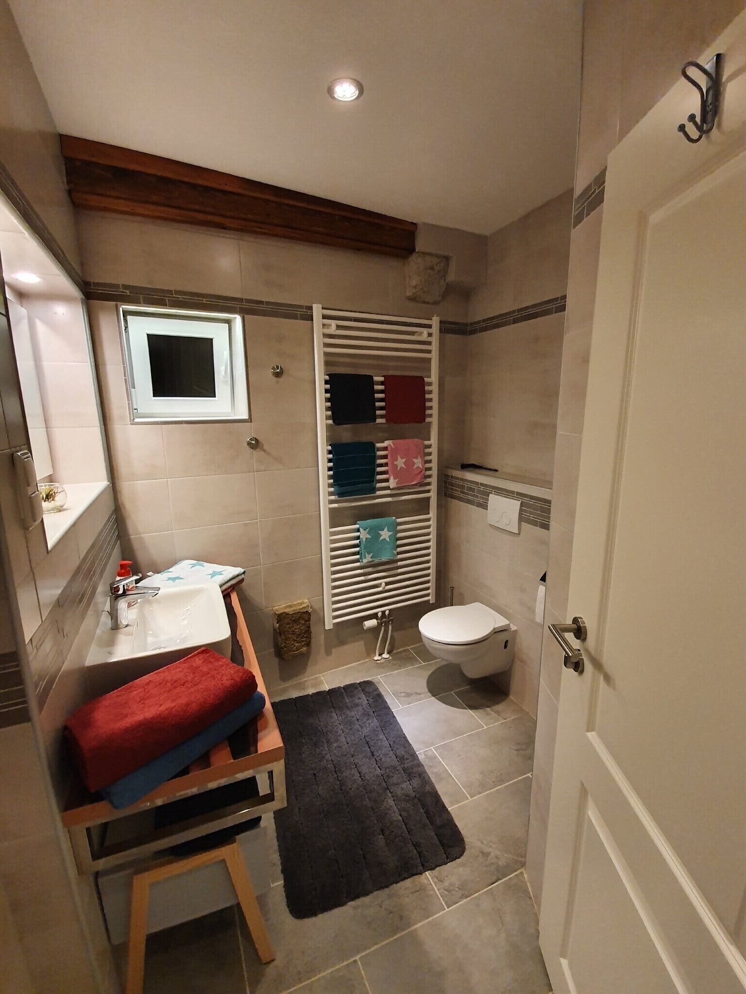 Une salle de bain équipée d’un lavabo, de toilettes, d’une douche et d’un porte-serviettes avec plusieurs serviettes.