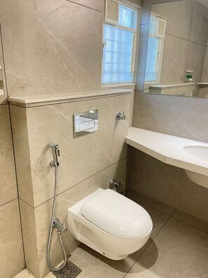 A bathroom with a toilet, a shower, a sink, and a mirror. - O'Nest Elite (Miraj)
