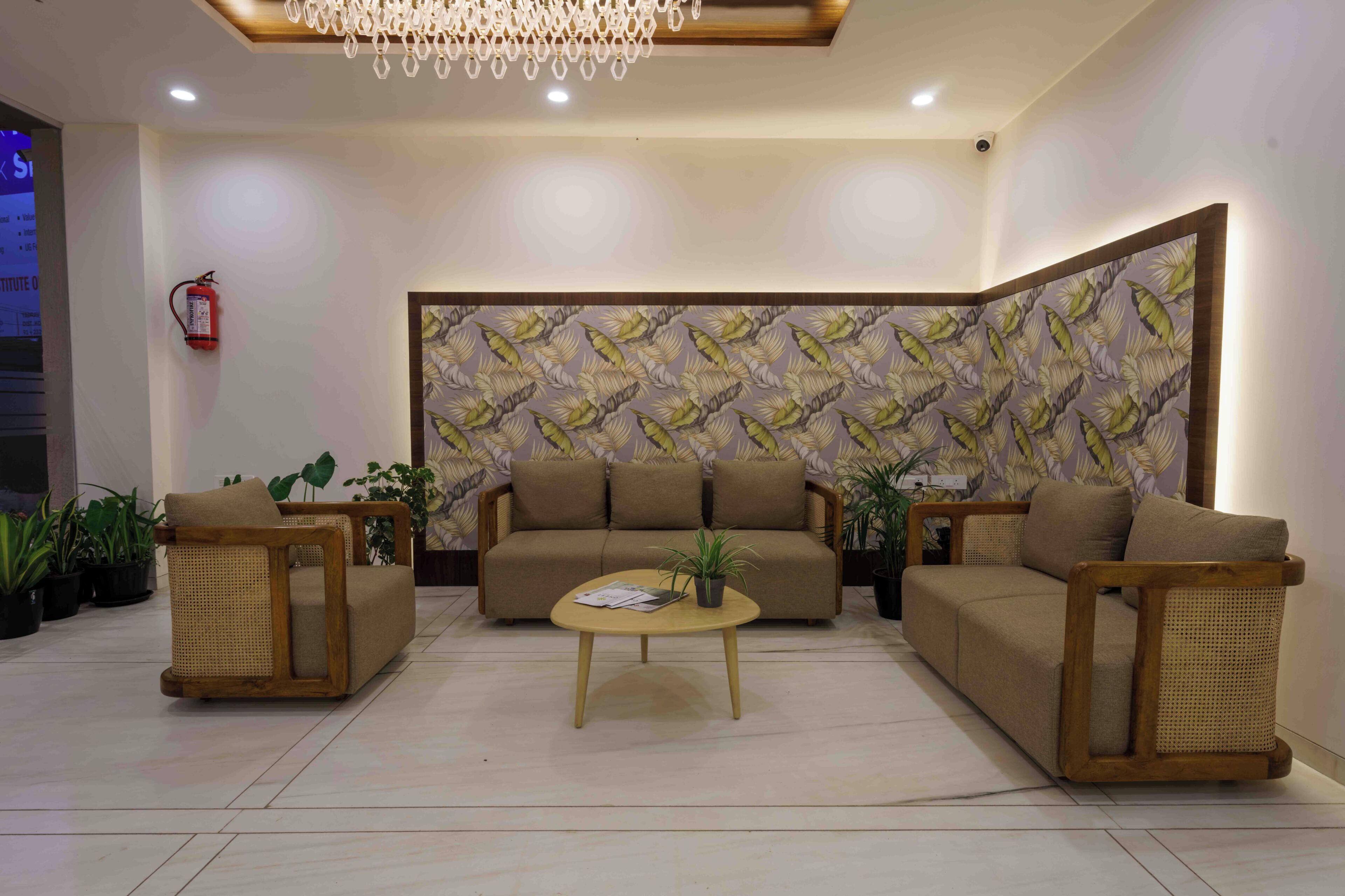 A modern living room with a sofa, two armchairs, a coffee table, and a decorative wall.