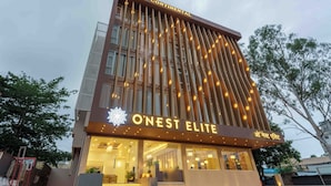 Ein Hotel mit moderner Fassade, einem gut sichtbaren Schild für 'O'Nest Elite' und einem einladenden Eingang.
