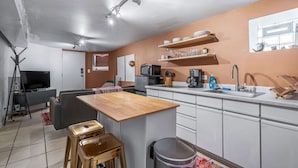 A compact kitchen with a wooden island, white cabinets, and a built-in microwave. - 3br with Private Entrance - Garden Unit (Chicago)