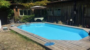 Une piscine rectangulaire entourée d’une terrasse en bois.