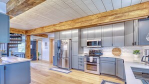 A modern kitchen with wooden beams, stainless steel appliances, and grey cabinetry. - Newly Remodeled Chalet with Hot Tub, Stunning Views, Minutes to Downtown Pagosa (Pagosa Springs)