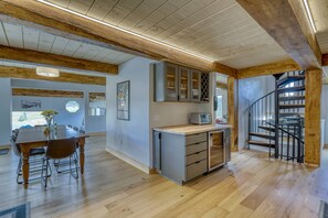 A spacious kitchen with wooden beams, a dining area with a large table and chairs, and a spiral staircase. - Last-Min Summer Escape! 15% Off Your August Stay. Must Book By 8/17/26. (Pagosa Springs)
