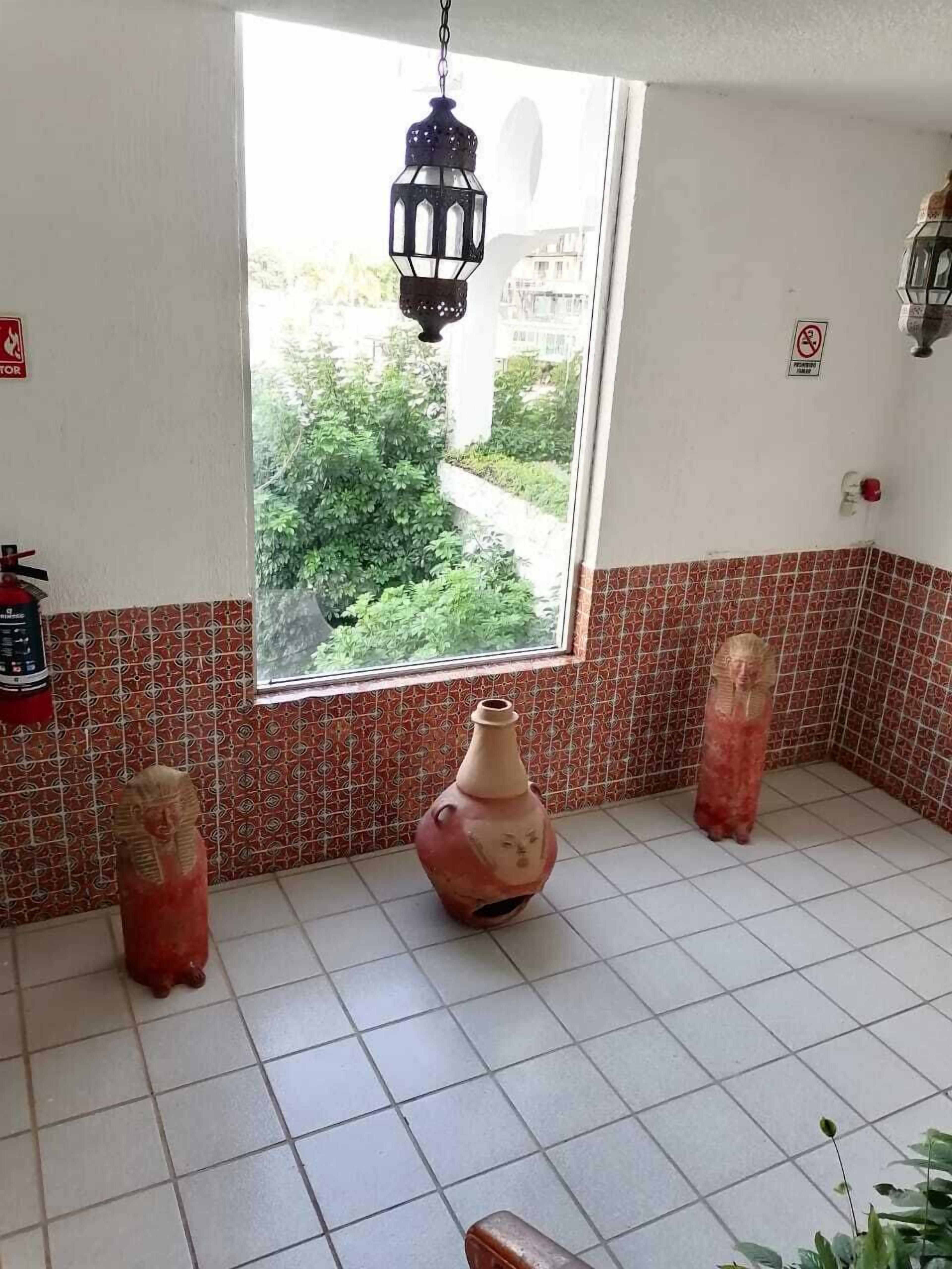 A bathroom with a window, tiled walls, and a hanging lantern.