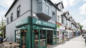 A coffee shop named LANS COFFEE with a green facade and large windows. - 3 BR Chic Home with Balcony & Free Parking! (Leeds)