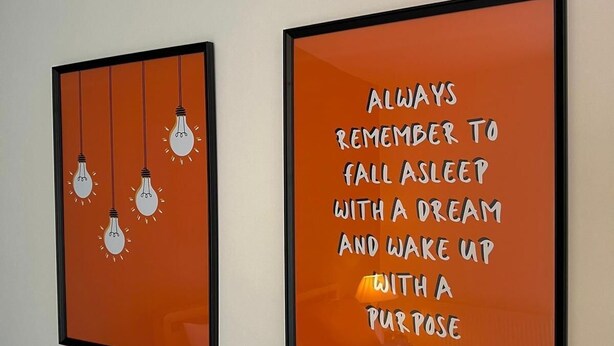 Twee kunstwerken in lijsten aan een muur.