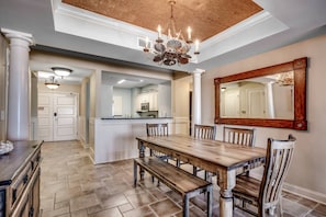 A dining area with a wooden table and benches, a chandelier, and a large mirror on the wall. - New to Rental! Stunning 15th Floor Oceanfront Condo at North Beach Resort-$300 FREE Activities Daily (North Myrtle Beach)